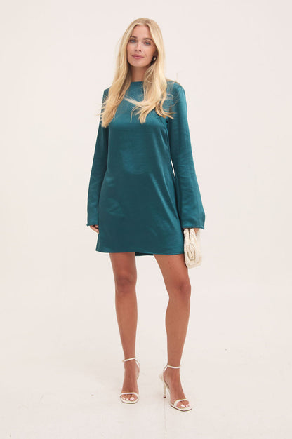 Woman wearing a teal dress against a white background